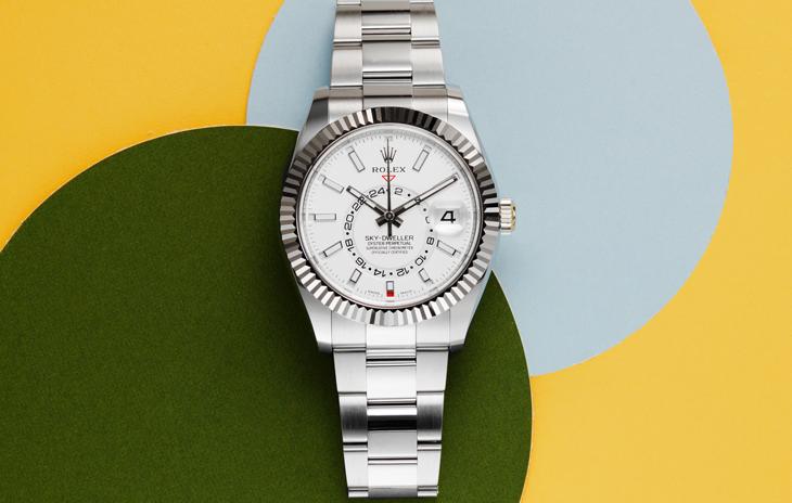 White Rolex Sky Dweller with green, blue, and yellow circles in background 